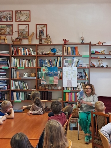 Zdjęcie prezentuje pierwsze spotkanie Powiatowego Klubiku Książki, które odbyło się 2 października 2026 r. w siedzibie biblioteki powiatowej. Spotkanie poprowadziła Dorota Opolska dla klasy 3a ze Szkoły Podstawowej nr 3 im. Jana Brzechwy w Puławach. Na zdjęciu uczniowie klasy 3a oraz Dorota Opolska czytająca legendę „Urszulin. Las, który słucha”.