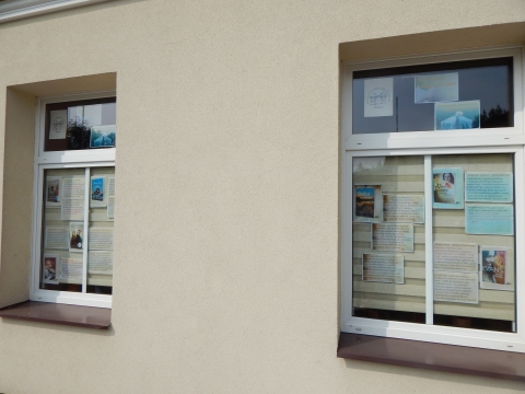 Zdjęcie prezentuje wystawę na oknach Powiatowej Biblioteki Publicznej w Puławach promującą  wakacyjne propozycje książkowe z wyrazem „słońce” w tytule. 