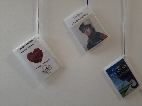 Zdjęcie prezentuje wystawę powieszoną na korytarzu przed biblioteką prezentującą różne okładki książek, których głównym tematem jest miłość. 