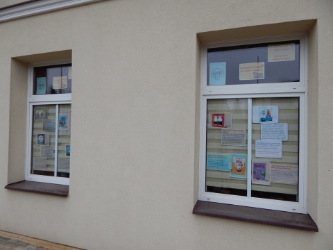 Zdjęcie prezentuje wystawę na oknach Powiatowej Biblioteki Publicznej w Puławach pt. „Literackie życzenia dla babci i dziadka”.