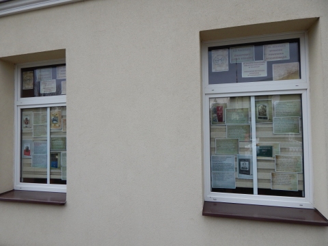 Zdjęcie prezentuje wystawę na oknach Powiatowej Biblioteki Publicznej w Puławach pokazującą różne publikacje dotyczące wybuchu i przebiegu Powstania Styczniowego.