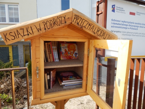Zdjęcie przedstawia budkę bookcrossingową znajdującą się przy wejściu do Obserwatorium Astronomicznego, przy ulicy Filtrowej 50 w Puławach.