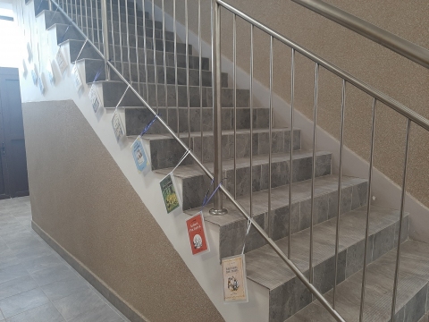 Zdjęcie prezentuje wystawę powieszoną na korytarzu przed biblioteką prezentującą różne okładki książek pt. „Kubuś Puchatek” 