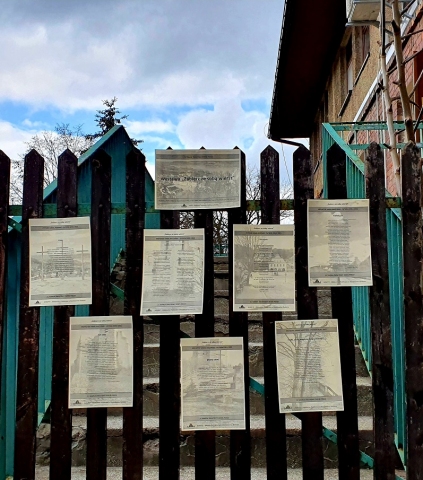 Wystawa "Zabierz ze sobą wiersz" - kartki z wierszami Cypriana Kamila Norwida i Krzysztofa Kamila Baczyńskiego zawieszone na płocie przed Biblioteką Publiczną