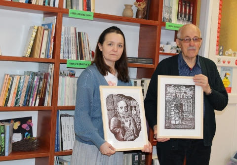 Zdjęcie prezentuje pana Zbigniewa Pieleszka puławskiego artystę plastyka, który przekazuje na ręce pani dyrektor Powiatowej Biblioteki Publicznej niezwykły prezent - dwa linoryty. 