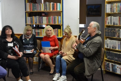 Zdjęcie prezentuje spotkanie poetycko – muzyczne Międzynarodowej Grupy Artystycznej „Pod wiatr”, które odbyło się w Bibliotece Publicznej w Kazimierzu Dolnym. 