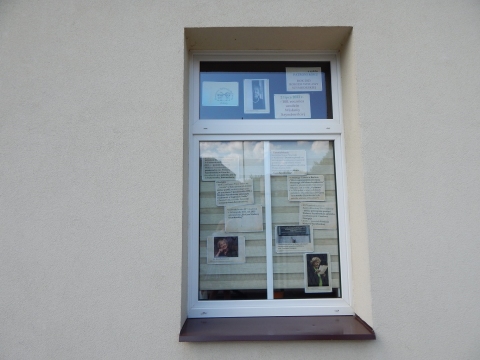 Zdjęcie prezentuje wystawę na oknach Powiatowej Biblioteki Publicznej w Puławach pokazującą życie i twórczość Wisławy Szymborskiej. 