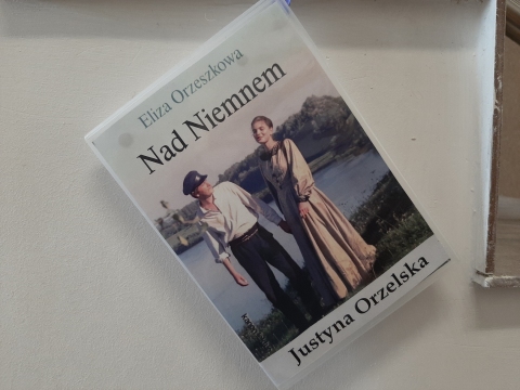 Zdjęcie prezentuje wystawę powieszoną na korytarzu przed biblioteką prezentującą różne okładki książek, w których ważna rolę odgrywają kobiety. 