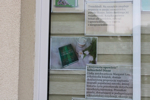 Zdjęcie prezentuje wystawę na oknach Powiatowej Biblioteki Publicznej w Puławach prezentującą utwory, w których głównym bohaterem jest książka. 