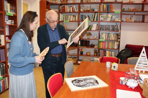 Zdjęcie prezentuje pana Zbigniewa Pieleszka puławskiego artystę plastyka, który przekazuje na ręce pani dyrektor Powiatowej Biblioteki Publicznej niezwykły prezent - dwa linoryty. 