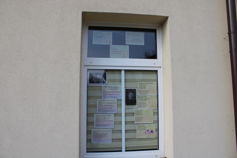 Zdjęcie prezentuje wystawę na oknach Powiatowej Biblioteki Publicznej w Puławach, prezentującą wiersze polskich poetów opisujące wiosnę oraz jej charakterystyczne motywy.