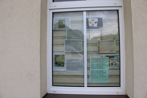 Zdjęcie prezentuje wystawę na oknach Powiatowej Biblioteki Publicznej prezentującą letnie propozycje czytelnicze dla najmłodszych.