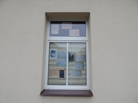  Zdjęcie prezentuje wystawę na oknach Powiatowej Biblioteki Publicznej w Puławach promującą  jesienne propozycje książkowe z wyrazem „deszcz” w tytule.