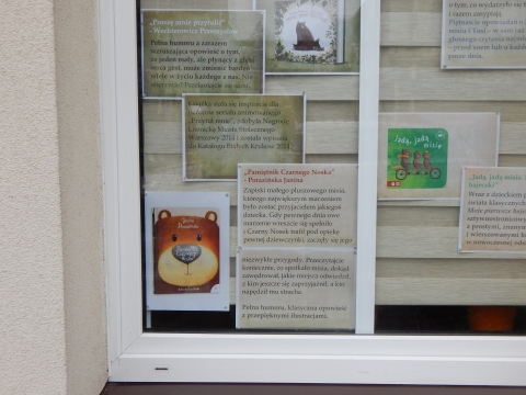 Zdjęcie prezentuje wystawę na oknach Powiatowej Biblioteki Publicznej w Puławach pokazującą książki, w których głównym bohaterem jest miś.