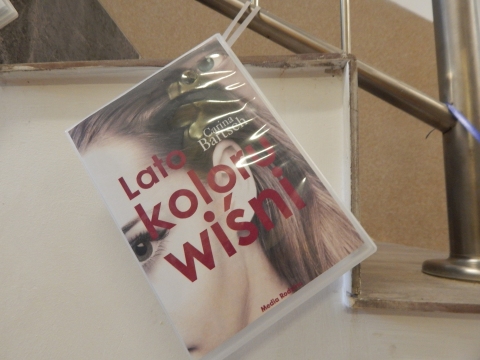 Zdjęcie prezentuje wystawę powieszoną na korytarzu przed biblioteką prezentującą różne okładki książek ze smakiem owoców  tytule.