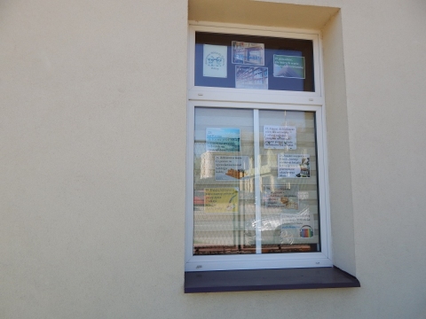 Wystawa na oknach biblioteki prezentująca 25 powodów dla których warto odwiedzić bibliotekę