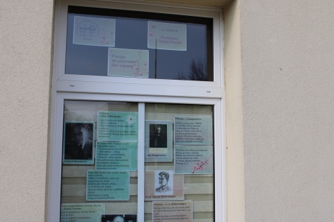 Zdjęcie prezentuje wystawę na oknach Powiatowej Biblioteki Publicznej w Puławach, prezentującą wiersze polskich poetów opisujące wiosnę oraz jej charakterystyczne motywy.