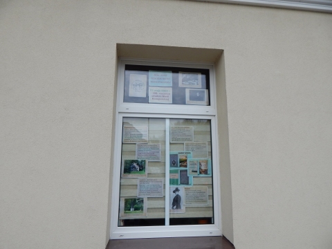 Zdjęcie prezentuje wystawę na oknach Powiatowej Biblioteki Publicznej w Puławach poświęconą życiu i twórczości Marii Konopnickiej.