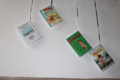 Zdjęcie prezentuje wystawę na korytarzu przed Powiatową Biblioteką Publiczną prezentującą letnie propozycje czytelnicze dla najmłodszych.