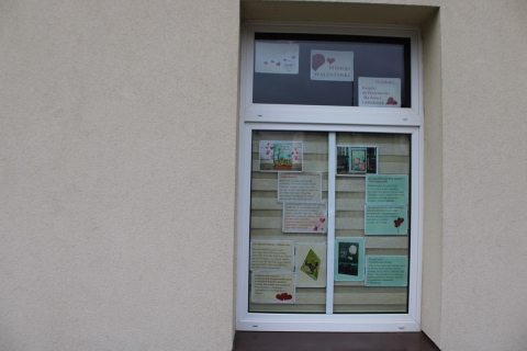 Zdjęcie prezentuje wystawę na oknach Powiatowej Biblioteki Publicznej w Puławach prezentującą książki o miłości dla dzieci i młodzieży.