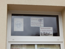 Zdjęcie prezentuje wystawę na oknach Powiatowej Biblioteki Publicznej w Puławach pt. „Ciekawostki z życia pisarzy”.