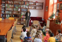 Zdjęcie prezentuje lekcję biblioteczną w Powiatowej Bibliotece Publicznej w Puławach, która odbyła się 16 kwietnia 2026 r. dla grupy Króliczki z Publicznego Przedszkola Integracyjnego w Puławach. Na zdjęciu widać dyrektora biblioteki Katarzynę Adamowską-Kane i przedszkolaki. 