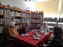 Zdjęcie prezentuje marcowe spotkanie kazimierskiego DKK, które odbyło się 12 marca 2026 w siedzibie biblioteki. Na zdjęciu widać pięć pań siedzących wokół stołu. 