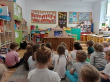 Zdjęcie prezentuje lekcję biblioteczną z cyklu "W magicznym świecie Kamishibai", która odbyła się 7 maja 2026 r. w klasach zerowych Szkoły Podstawowej nr 2 im. K.K. Baczyńskiego w Puławach. Na zdjęcie widać siedzące w klasie dzieci, które patrzą w kierunku otwartego teatrzyku Kamishibai. 