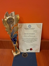 Zdjęcie prezentuje dyplom i puchar dla Powiatowej Biblioteki Publicznej w Puławach przyznany przez Oddział Rejonowy w Puławach Polskiego Związku Emerytów i Rencistów z okazji 60-lecia działalności.